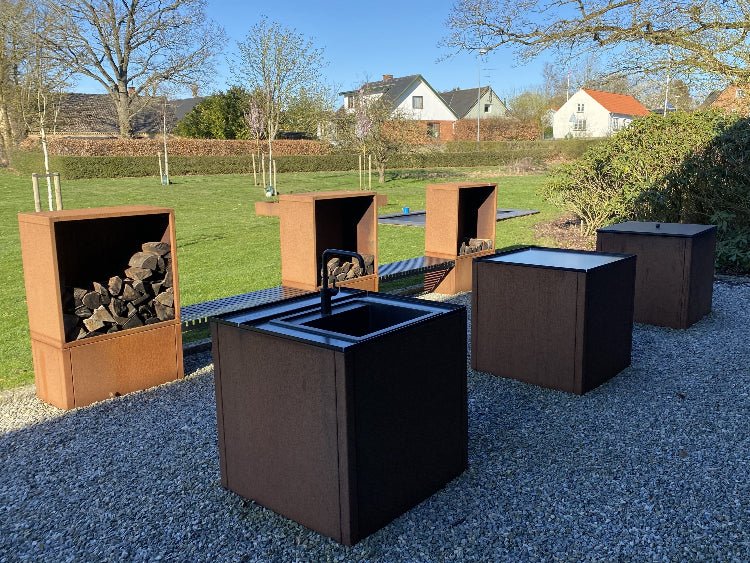 Utekök i cortenstål med integrerad vedförvaring och sittbänk