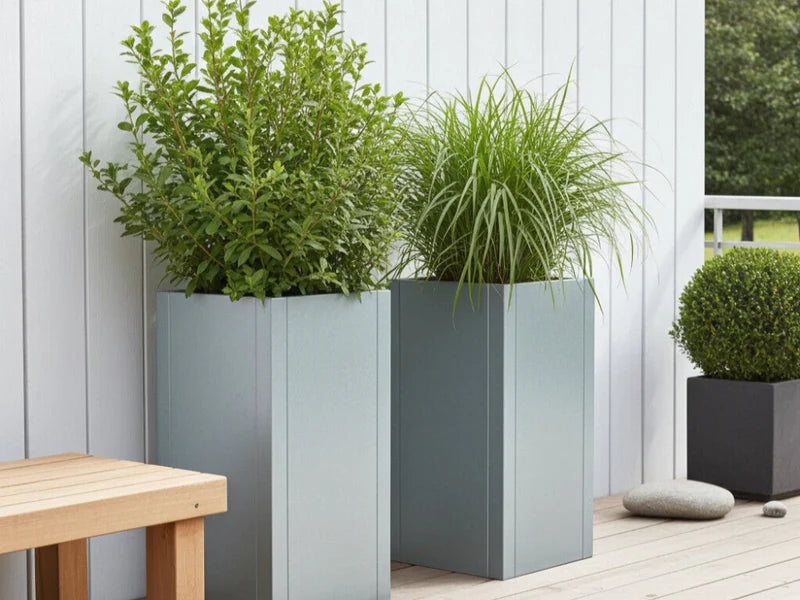 CUBY blomlåda i galvaniserat stål placerad på modern terrass med gröna växter