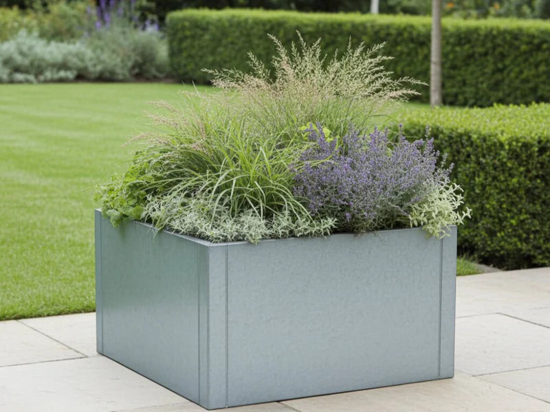 CUBY kvadratisk blomlåda i galvaniserat stål med prydnadsgräs i trädgård