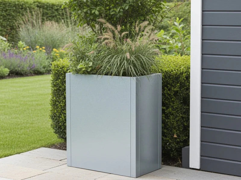 CUBY hög blomlåda i galvaniserat stål med prydnadsgräs vid modern fasad