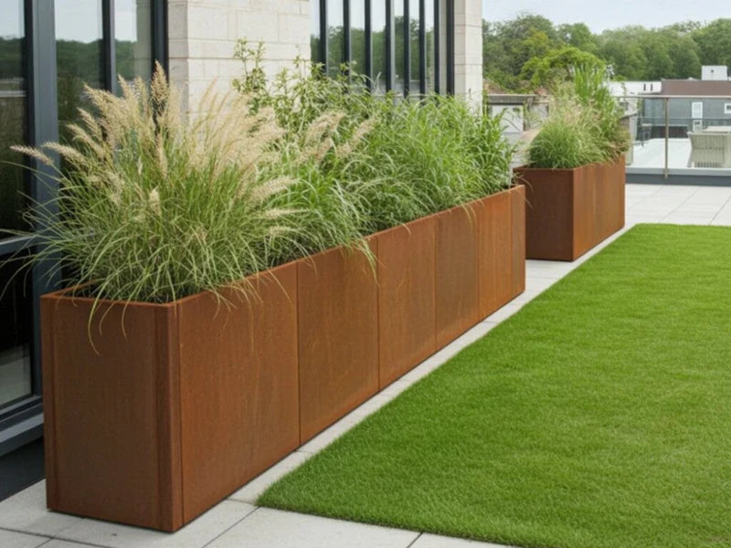 Lång blomlåda i cortenstål från CUBY med prydnadsgräs