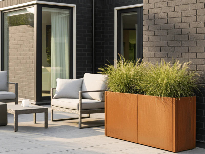 Blomlåda i cortenstål från CUBY med gräsplantering vid terrass