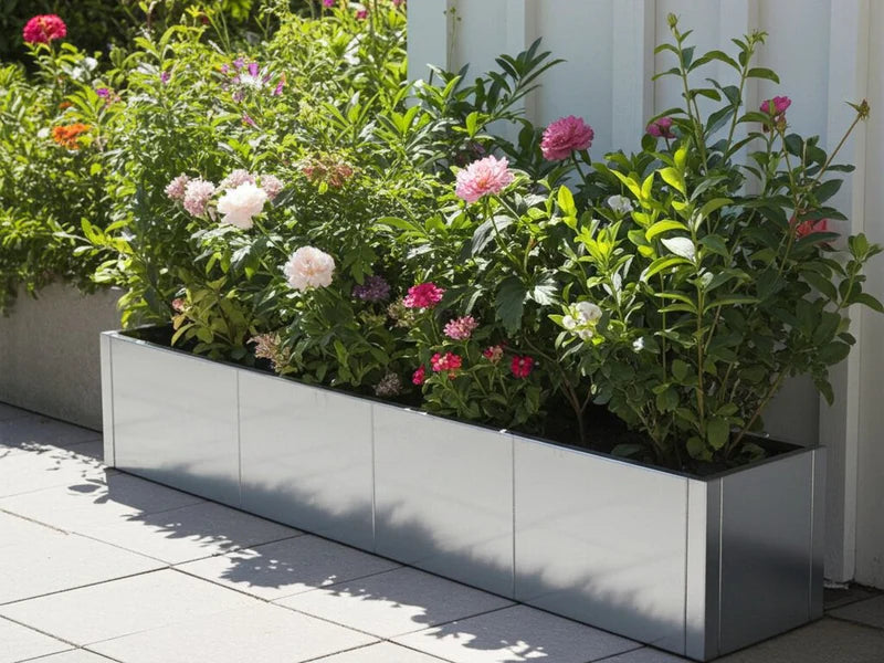 Lång blomlåda i galvaniserat stål från CUBY med blommande växter