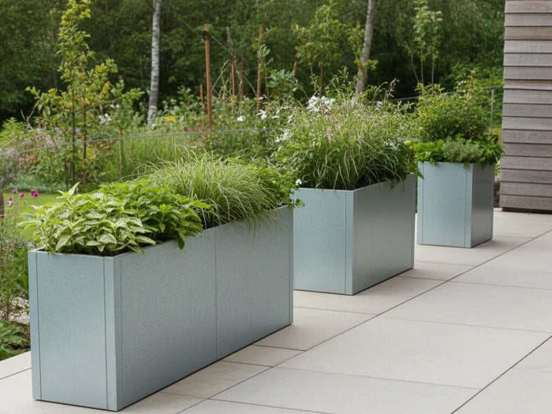 Blomlådor i galvaniserat stål från CUBY med perenner längs terrass