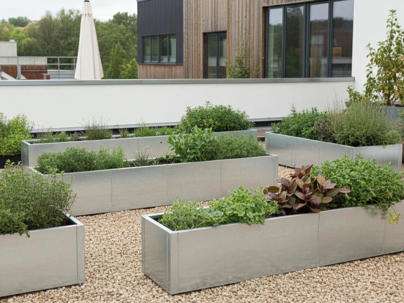 Odlingslåda i galvaniserat stål från CUBY med grön plantering i gårdsmiljö