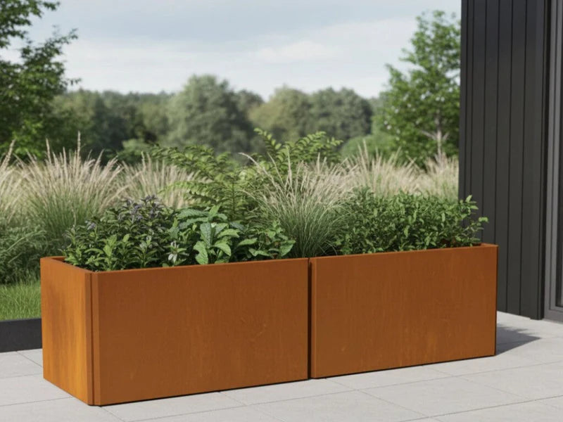 EDGY blomlåda i cortenstål med gräs på terrass vid modern fasad