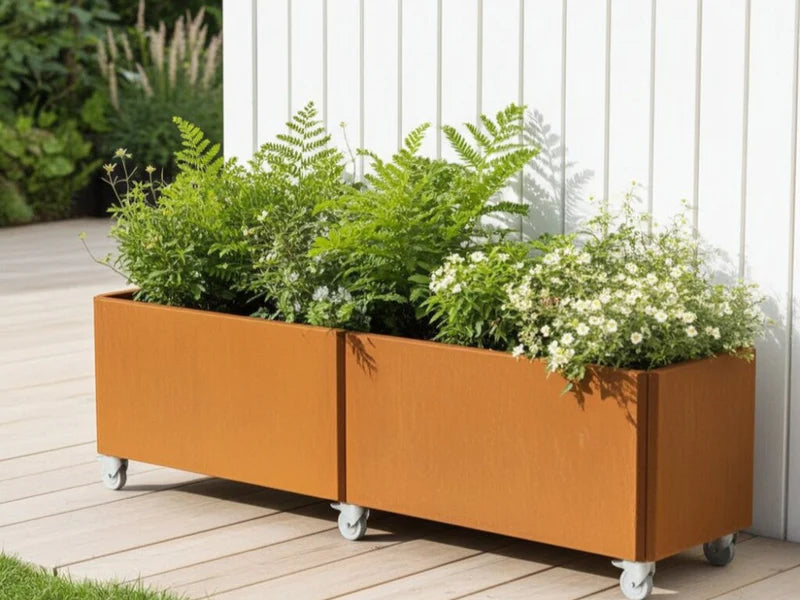 EDGY blomlåda i cortenstål med ormbunkar på träterrass