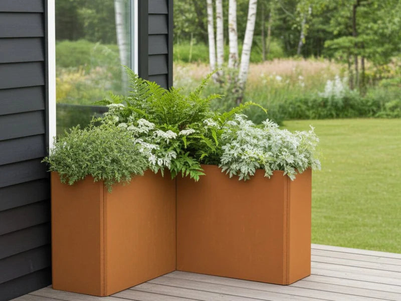 Hög vinkelformad EDGY blomlåda i cortenstål vid modern fasad