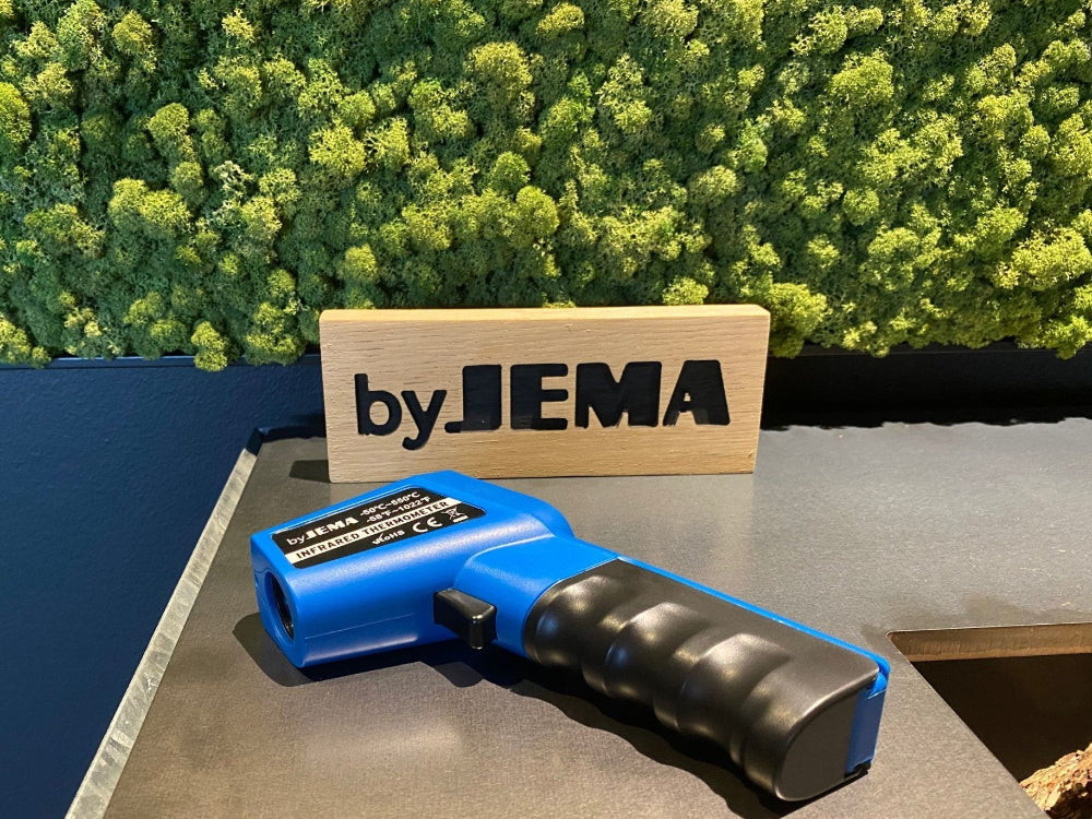 Infraröd termometer placerad vid grill i utomhusmiljö