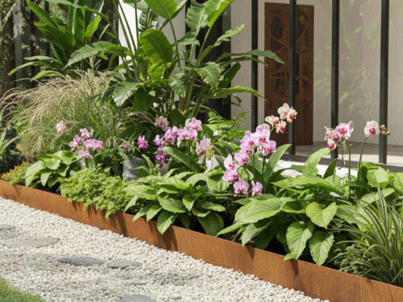 Rabattkant i cortenstål med tropiska växter längs terrass