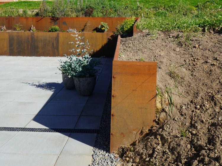 Ändplatta till stödmur i cortenstål i planteringsbädd