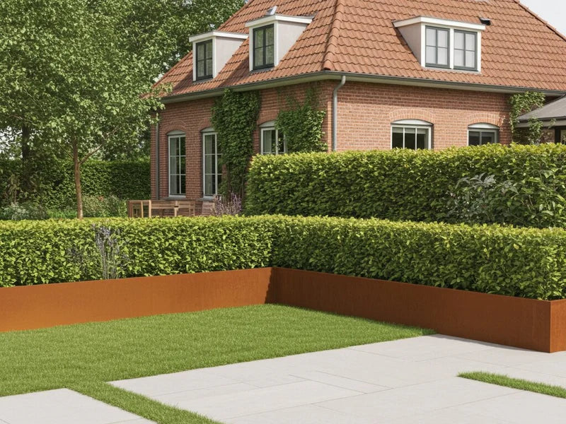 Stödmur i cortenstål runt planteringsbädd vid hus