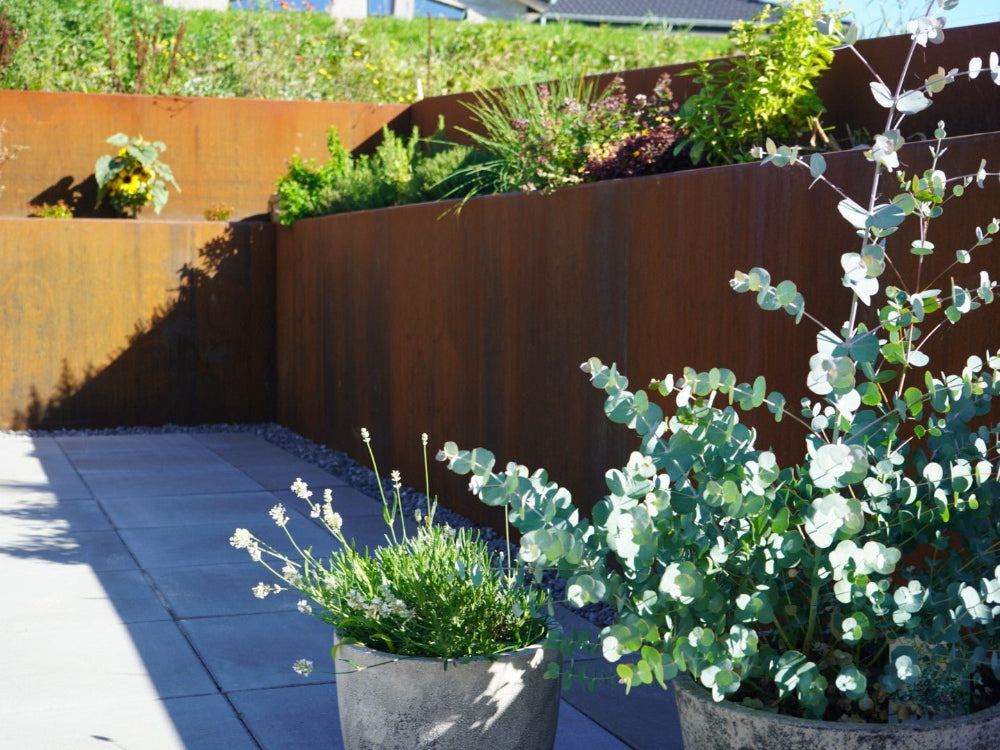 Stödmur i cortenstål runt planteringsbädd vid terrass