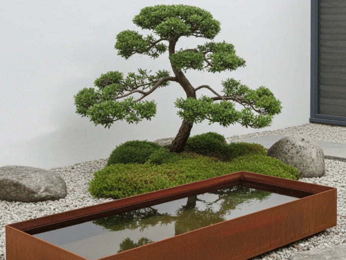 Rektangulart vattenkar i cortenstål som stilren vattenspegel i japanskinspirerad trädgård