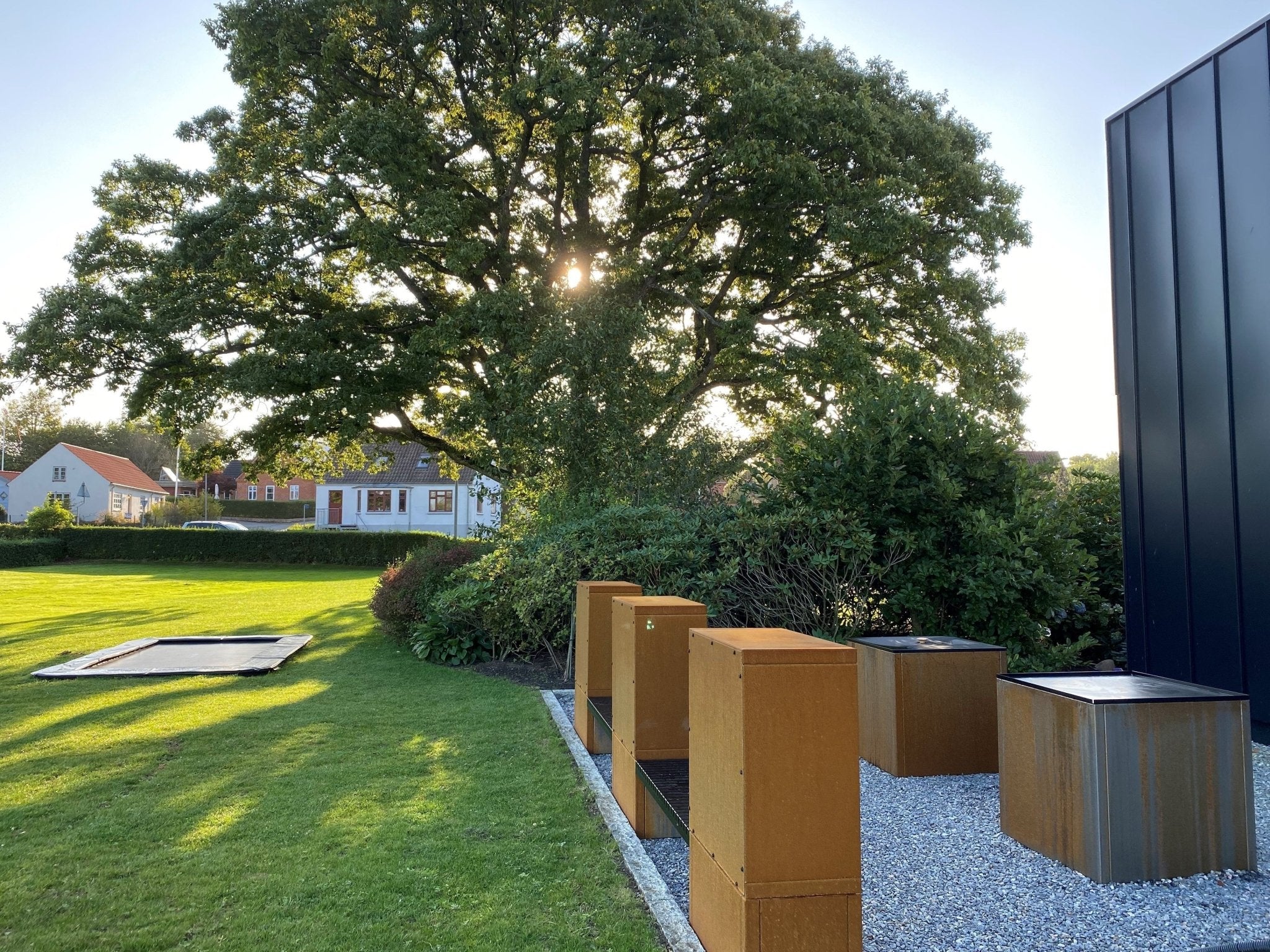 Vedlagring i cortenstål med sittbänk på modern terrass