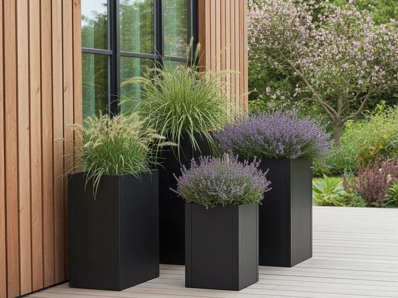 Höga blomkrukor i svart stål med prydnadsgräs