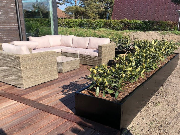 Lång byJEMA CUBY odlingslåda i svartlackerat stål som avgränsning vid terrass