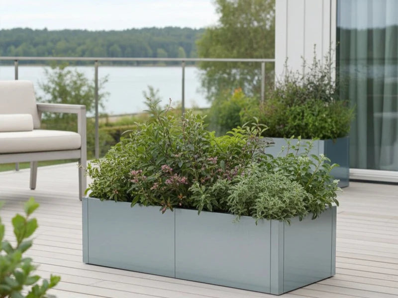 CUBY låg blomlåda i galvaniserat stål med gröna växter på terrass med utsikt