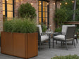 Stor blomlåda i cortenstål från CUBY vid sittgrupp på träterrass