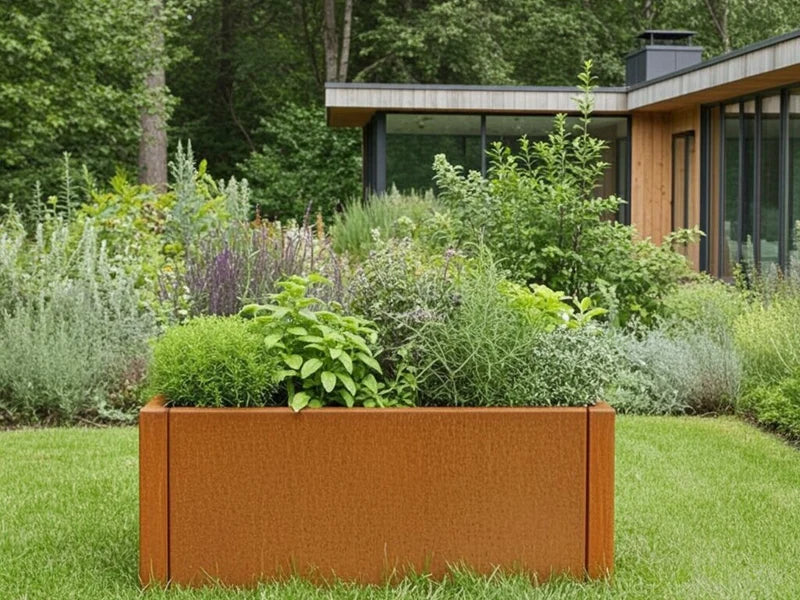 CUBY blomlåda i cortenstål med grön plantering vid modernt hus