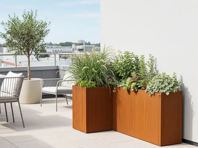 CUBY blomlåda i cortenstål i vinkel fylld med grönska på takterrass