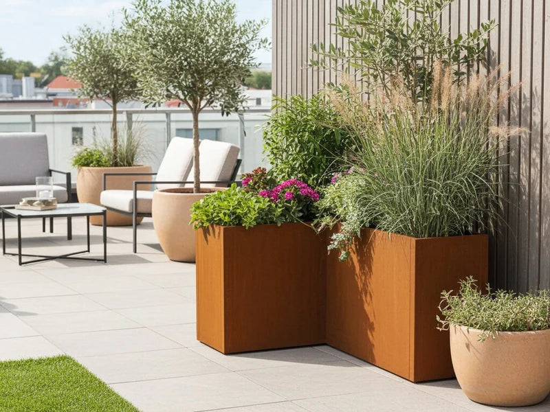 Vinkelblomlåda i cortenstål från CUBY med blommor på terrass