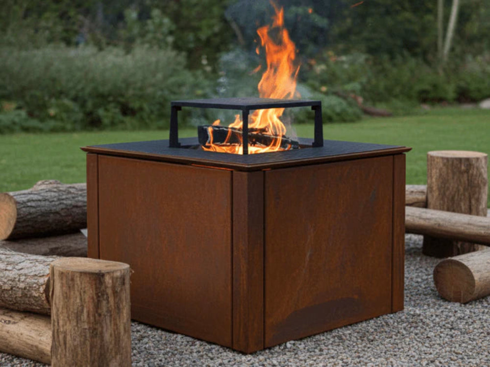 CUBY eldgrill i cortenstål med eld i trädgård