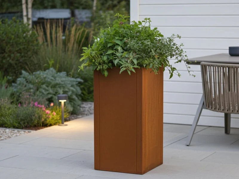 CUBY blomlåda i cortenstål med växter på terrass