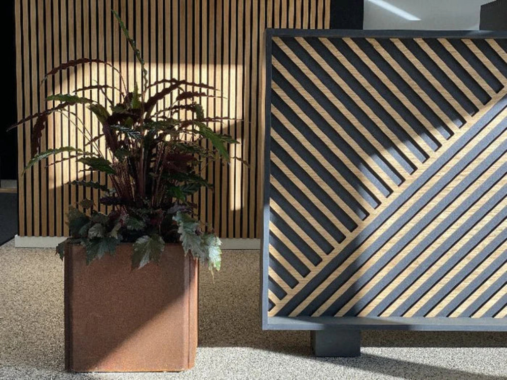 Blomlåda i cortenstål i designmiljö med träpanel