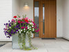 blomlåda i galvaniserat stål vid entré med blommor