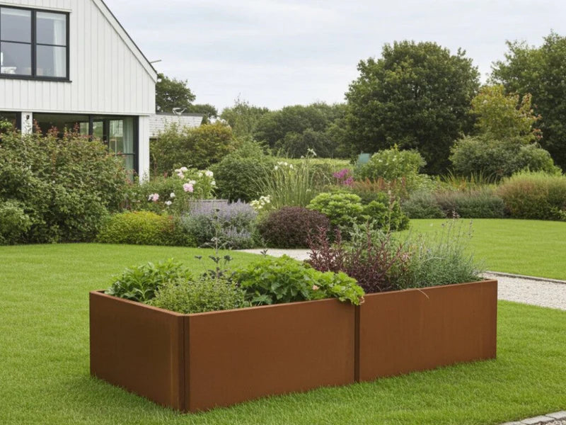 EDGY rektangulär odlingslåda i cortenstål med frodig plantering i trädgård