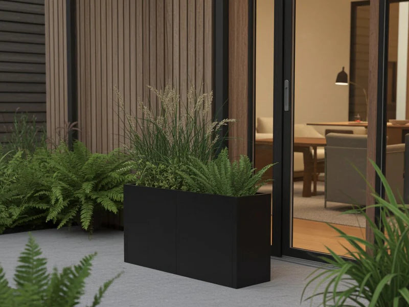 Minimalistisk blomlåda i svart stål med ormbunkar