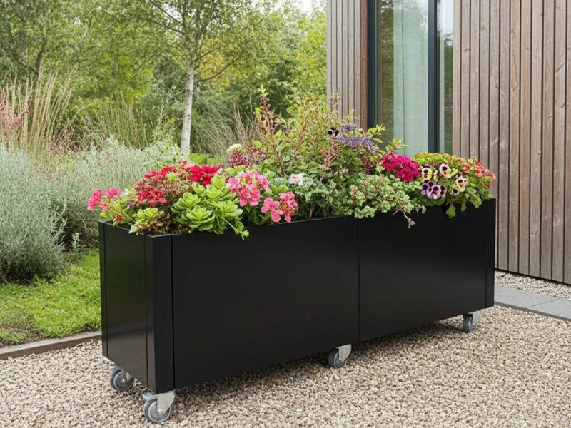 Mobil blomlåda i svart stål med sommarblommor på hjul