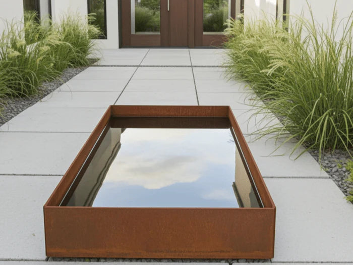 Rektangulart vattenkar i cortenstål vid modern entré